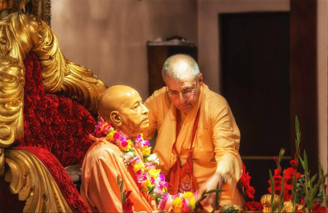 Гирирадж Свами надевает цветочную гирлянду на мурти Шрилы Прабхупады